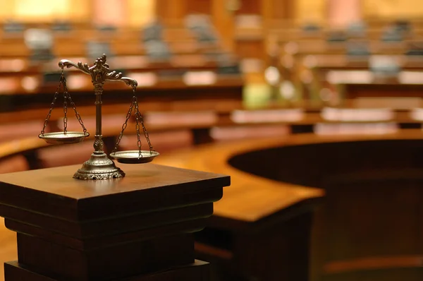 Balança da justiça em sala de audiência